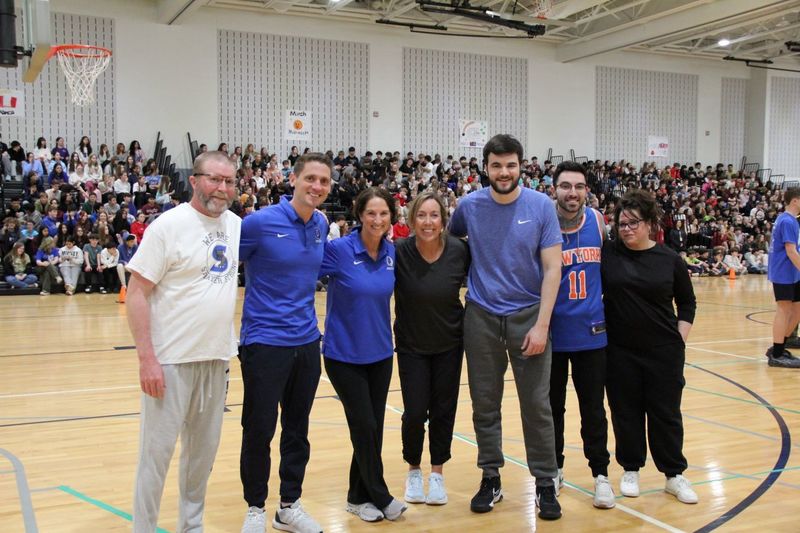 The "staff team" posese for a photo.