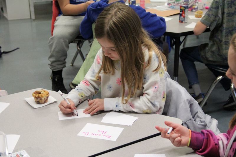 Students writing inspiring cards for their classmates to read during PSSA assessments