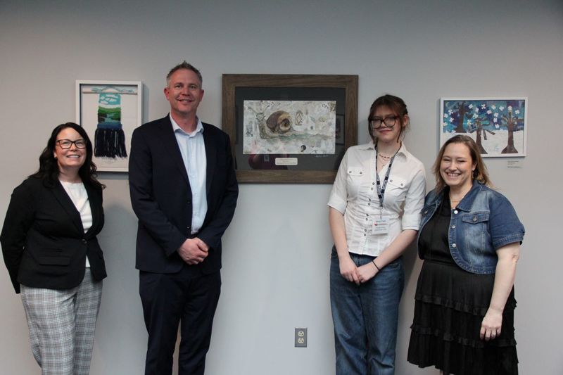 Principals, Dr. V and Ms. Lannutti, and Ms. Migliore smile with Ms. Clark and her artwork