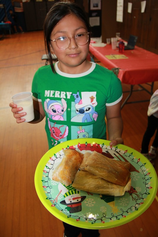 Student stops to smile while she enjoys food from Cultures Day