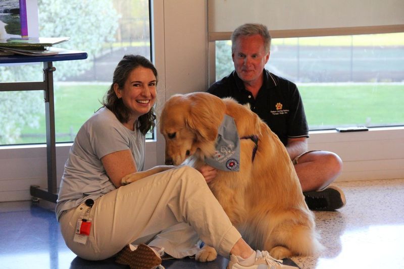 Mrs. Derr pets therapy dog, Malta at Neidig Family Fun Night.