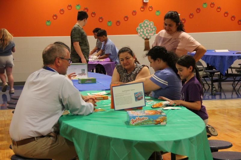 Families play literacy games in the cafeteria
