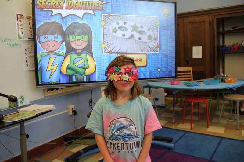 A student shows her amazing mask she created by wearing it.