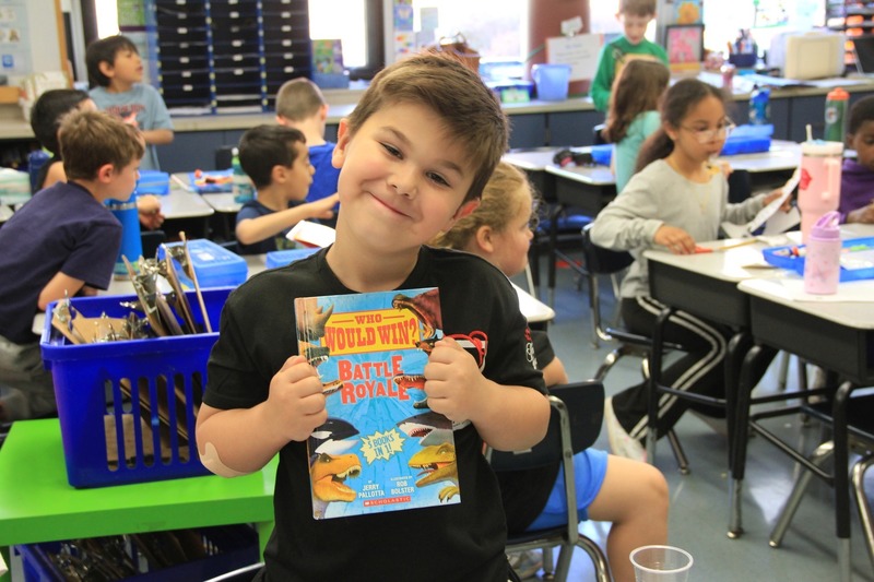 Student smiles with their new book