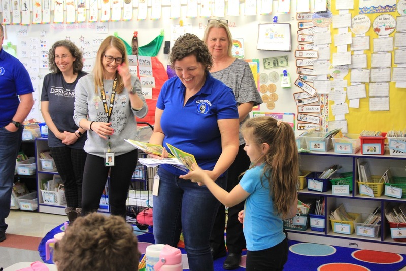 Dr. Hoffman gives a book to a first grader