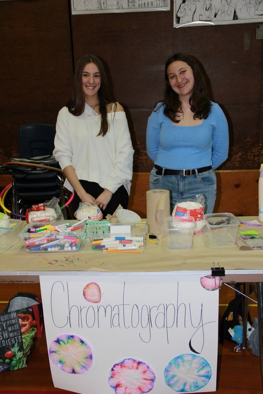 High school students stand behind their Chromatography station