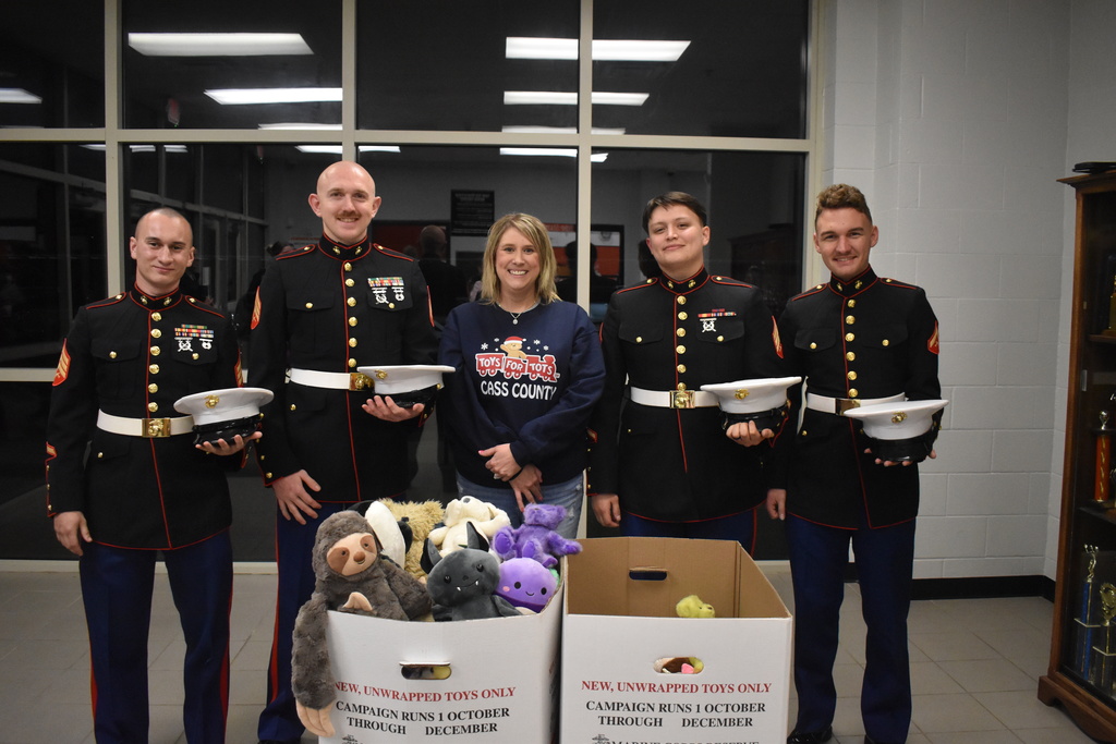 Marines and Megan Adcock pictured with Toys for Tots stuffed animals collected during Santa Slam