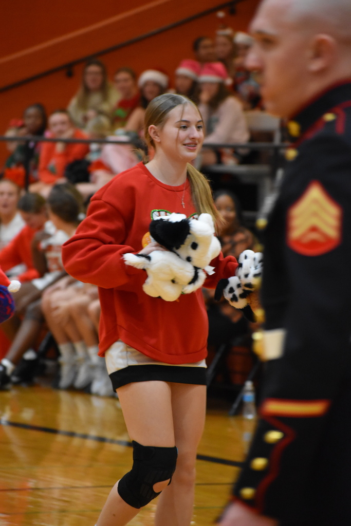 Cheerleaders picking up stuffed animals during Santa Slam