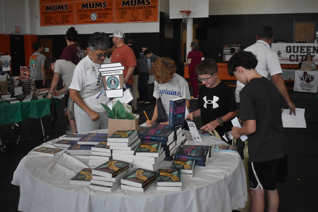 Students checking out realistic fiction book choices