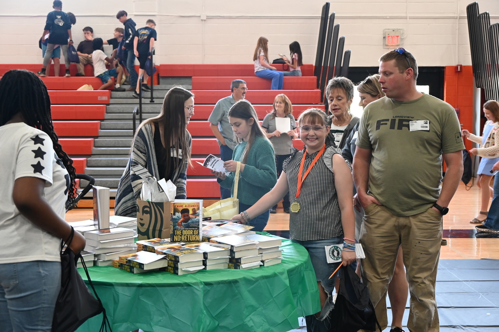 student smiling as she picks out a book