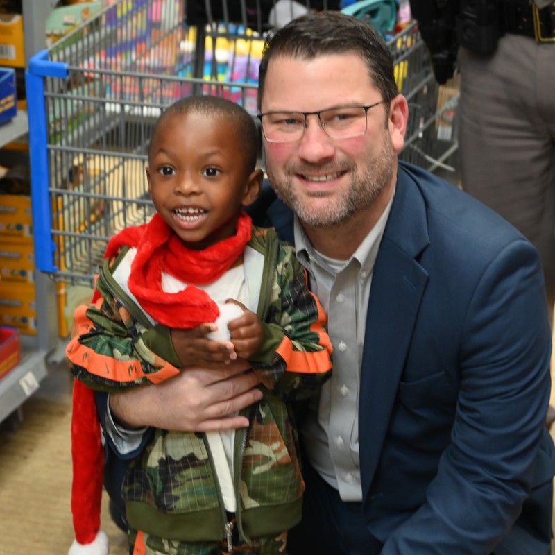stucent pictured with QCISD superintendent Casey Nichols during annual Shop with a Cop Event