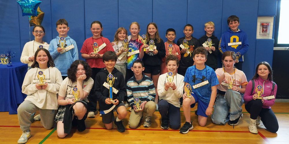 Students stand with trophies from WHBI Spelling Bee.