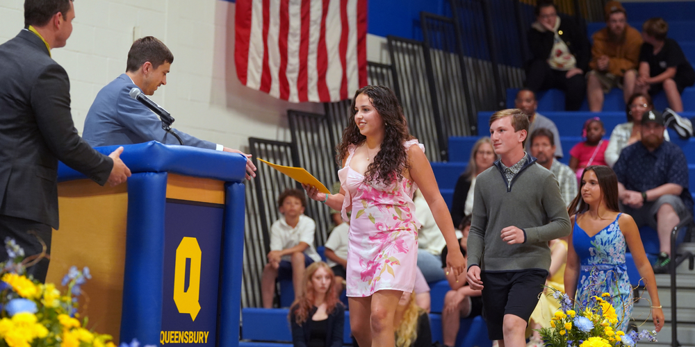 Students walk on stage at Moving-Up Ceremony.