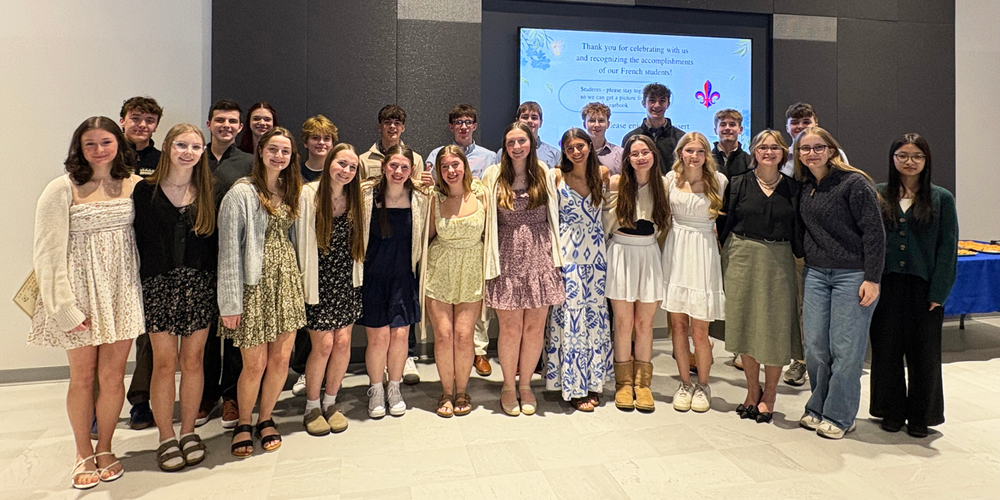 New French Honor Society students stand in group with current members.