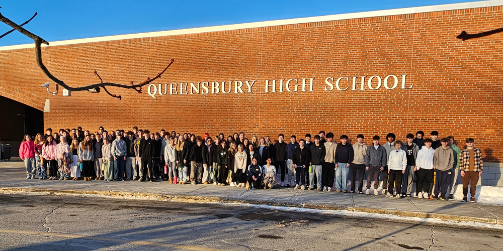 About 100 grade 10 students stand outside of Queensbury High School before a field trip.