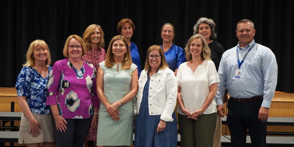 Retirees stand together on risers.