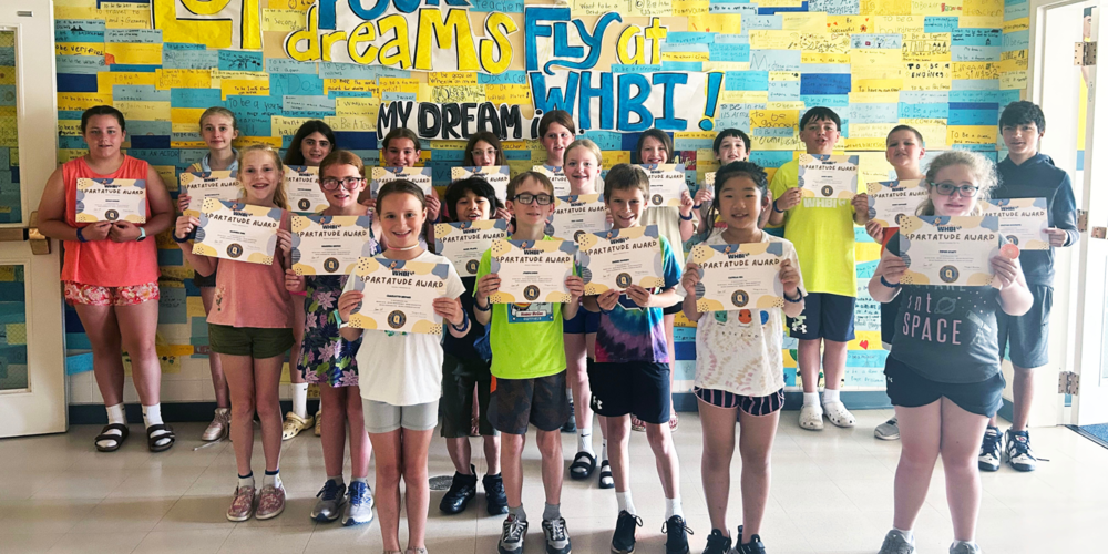 Students stand with certificates. 