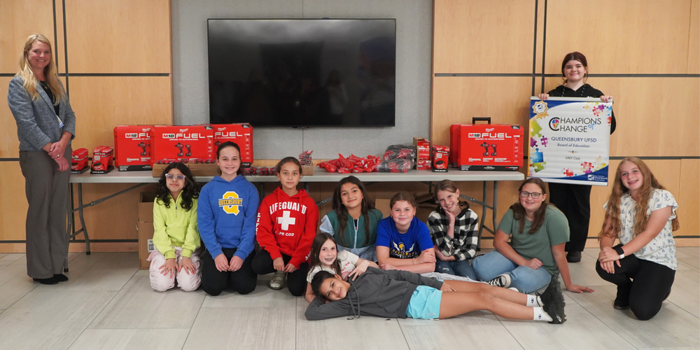 Girls sit in front of donated tools with GRIT club advisor Sam Gailor, left.