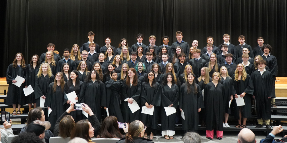 High school juniors stand in robes after being inducted into National Honor Society.