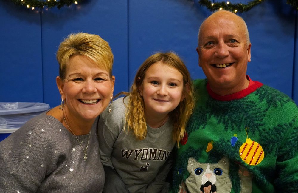 Grandparents pose with grandchild.