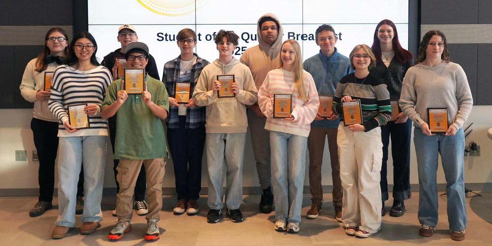 Students of the Quarter stand with plaques. 