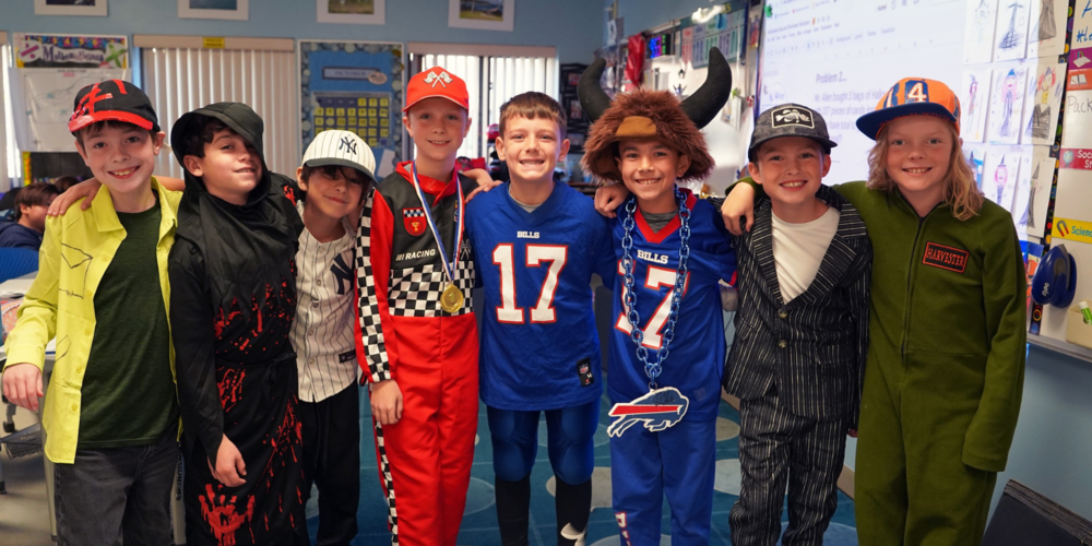 Students in Halloween costumes stand for a photo.
