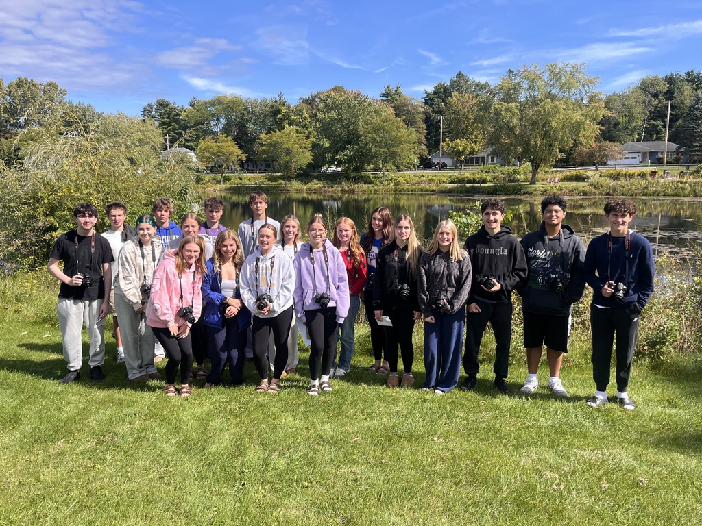 Students holding cameras at nature park.