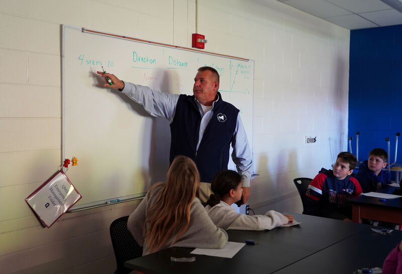 Students get a lesson from a land surveyor at QMS.