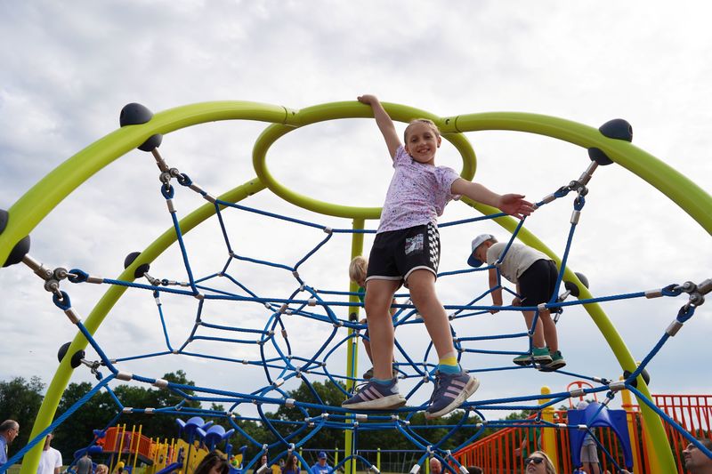 Student climbs on playground equipment.