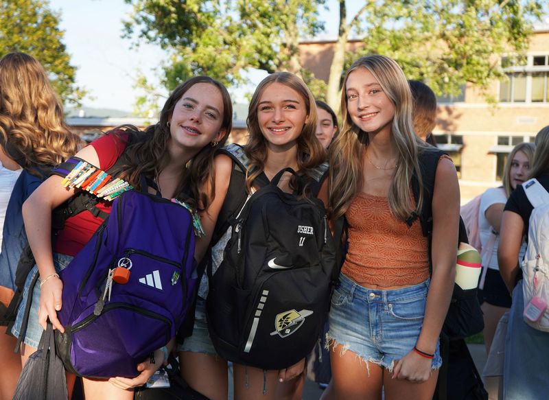 Three students stand outside of QMS before school.