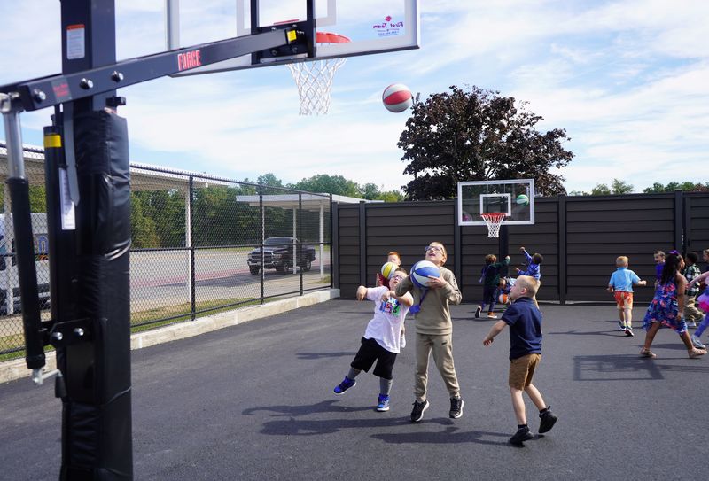 Students play basketball outside after lunch.