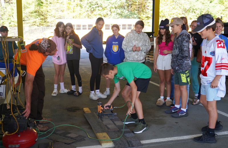 Student tries a nailing roofer during CTE Day.