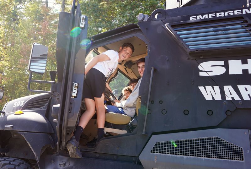 Students sit in an emergency vehicle during CTE Day.