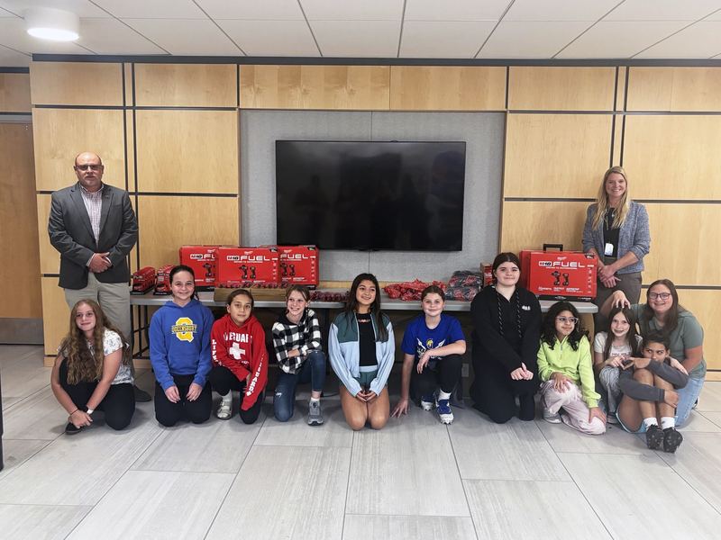 Mike Jarvis, left, poses with donated tools and members of the GRIT club, including advisor Sam Gailor, right.