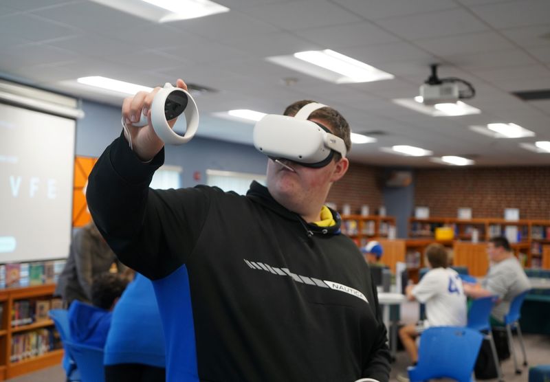 Student tries VR goggles to explore careers.