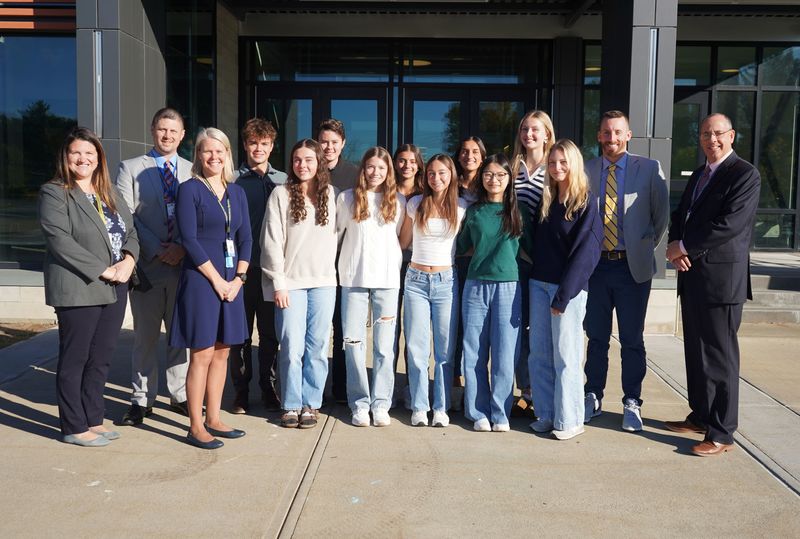 Top 10 students stand with administrators.