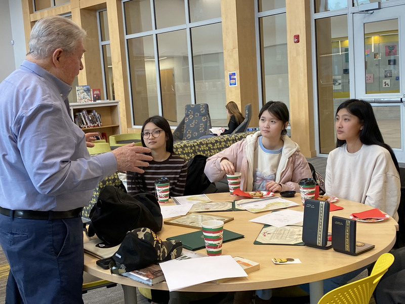 Students talk to veteran.