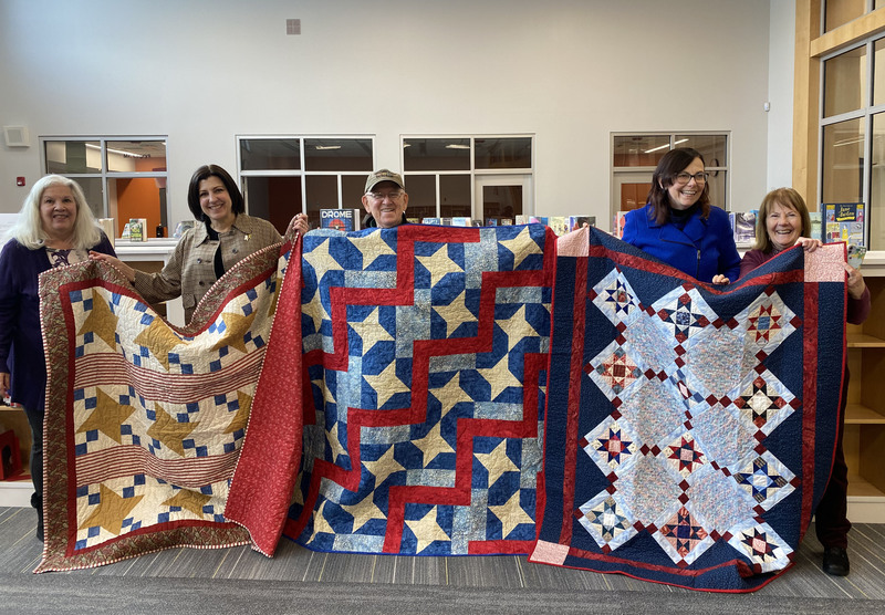 Quilters show off quilts made for veterans.
