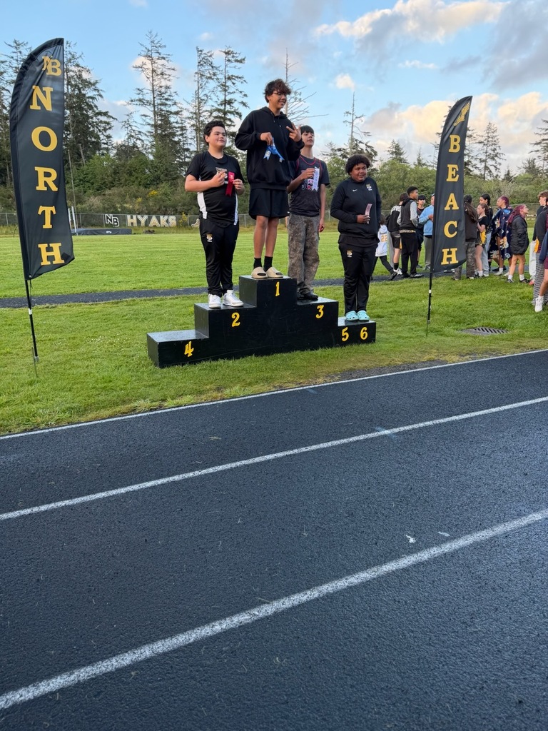 Boys Track and field standing podium with track athletes standing on it. 