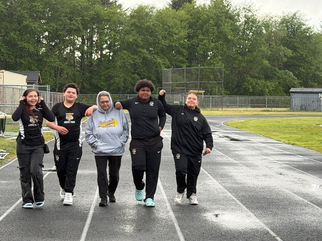 Track and Field athletes walking with Coach Mary in the center.