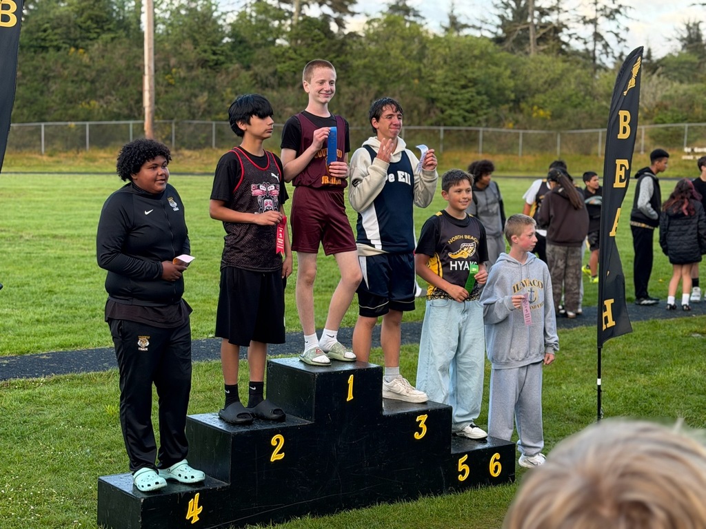 Boys Track and field standing podium with track athletes standing on it. 