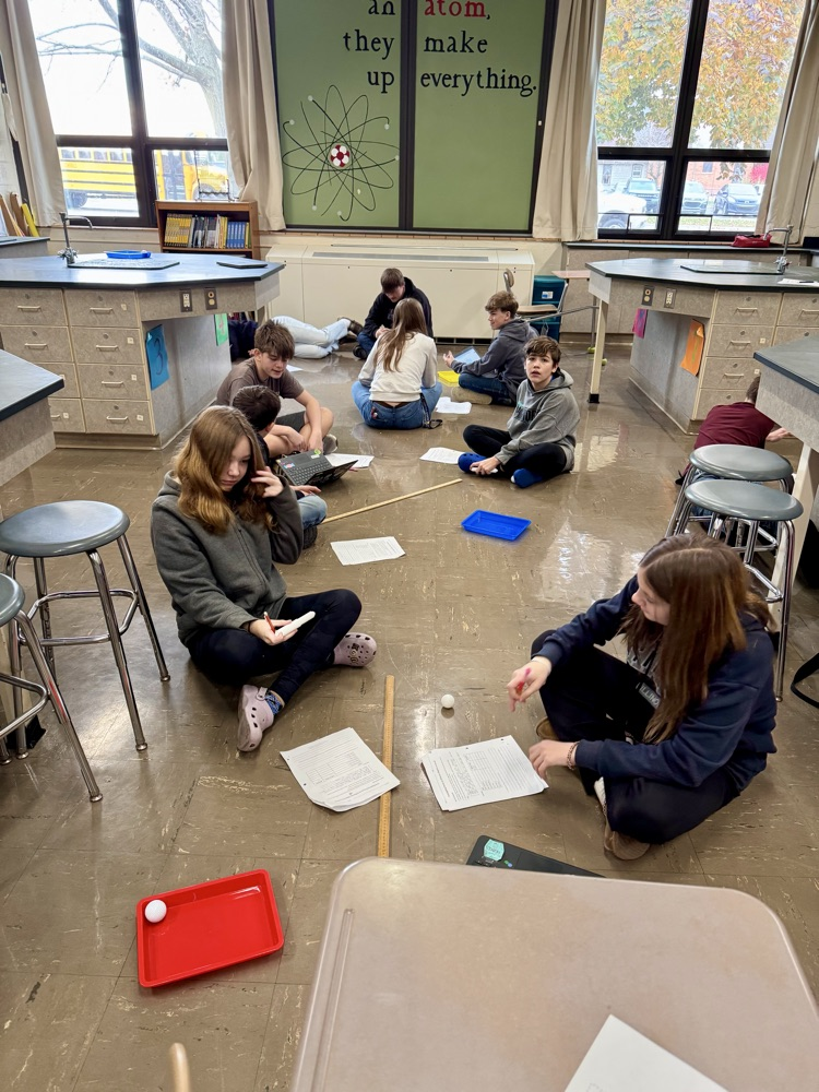 Students investigating force, mass, and velocity.