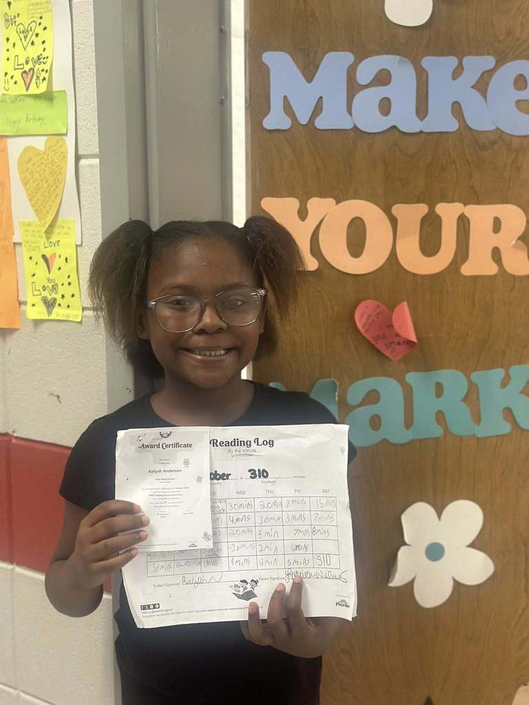 student holding award for reading 