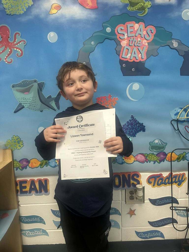 student holding award for reading 