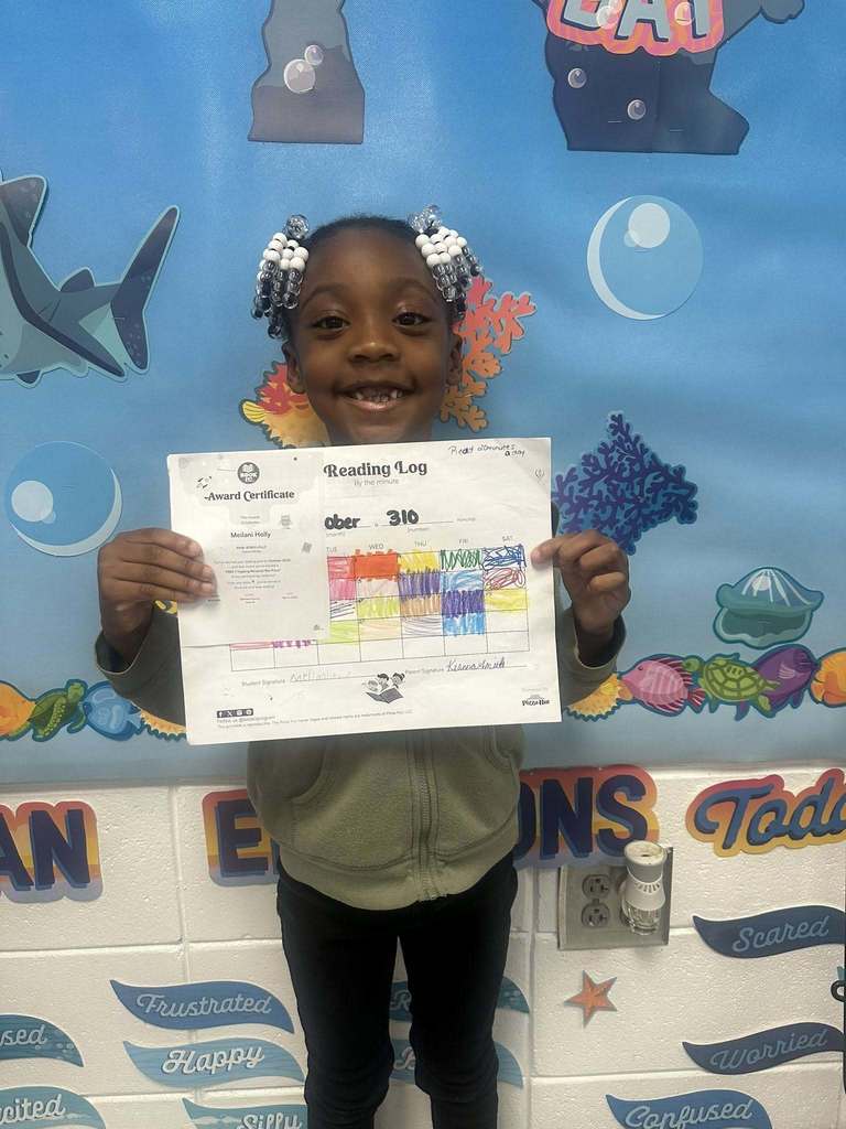 student holding award for reading 