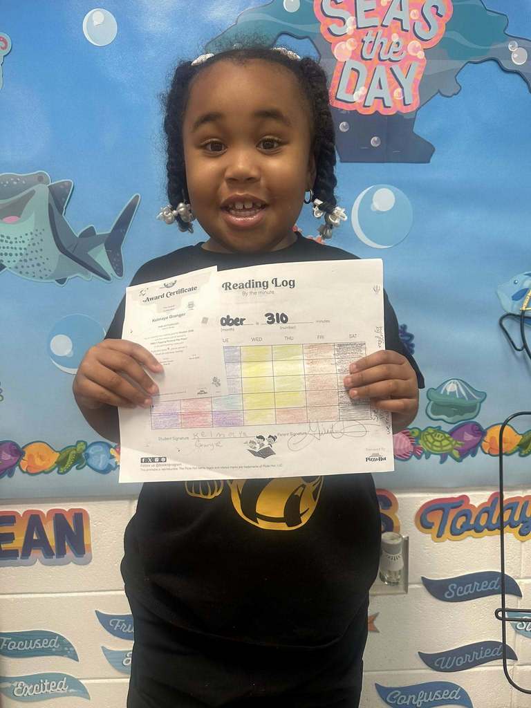 student holding award for reading 