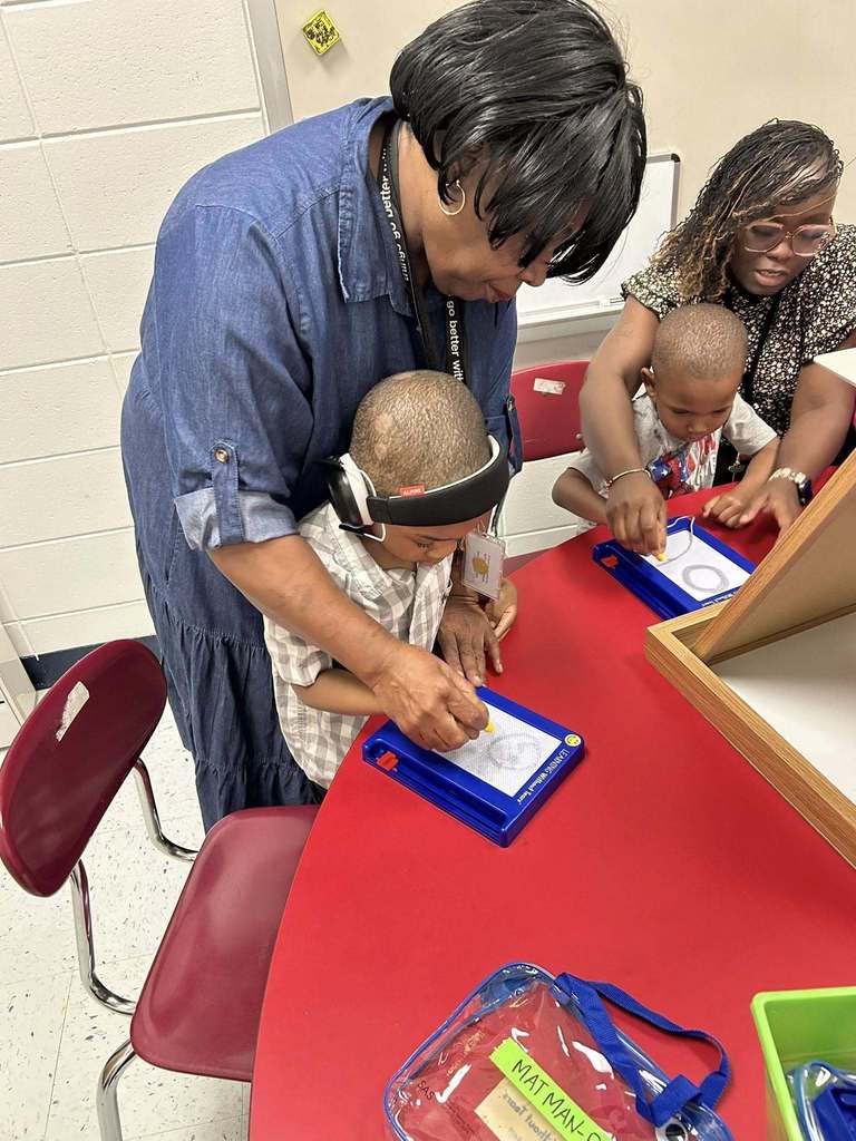 Teacher and student working on a project together at table
