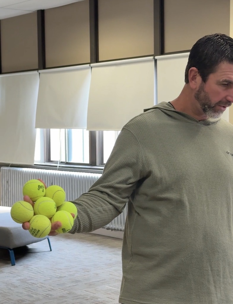 Marcus Hanel holding seven tennis balls in one hand.