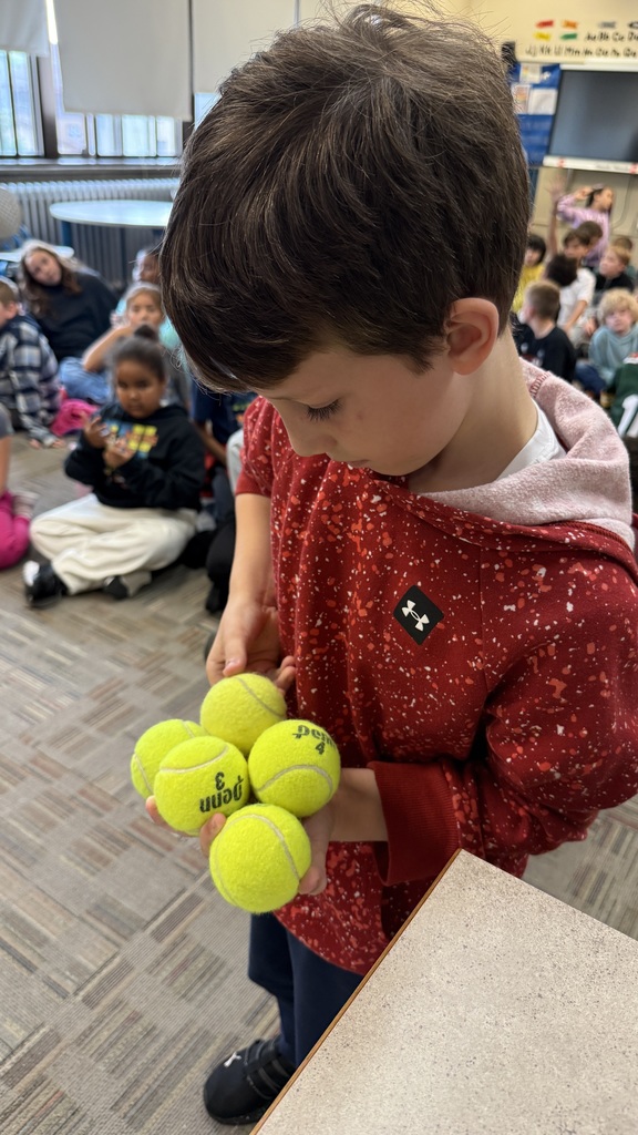 A student attempting to hold seven baseballs with one hand