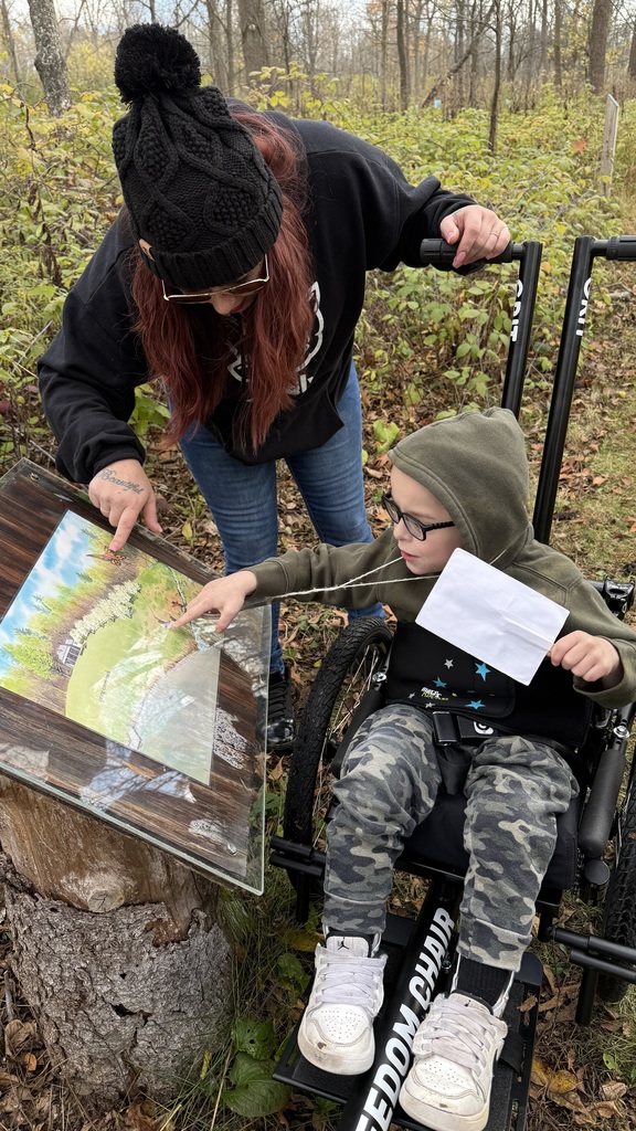 Angel Martz and his mother reading an educational sign at Riverbend Nature Center